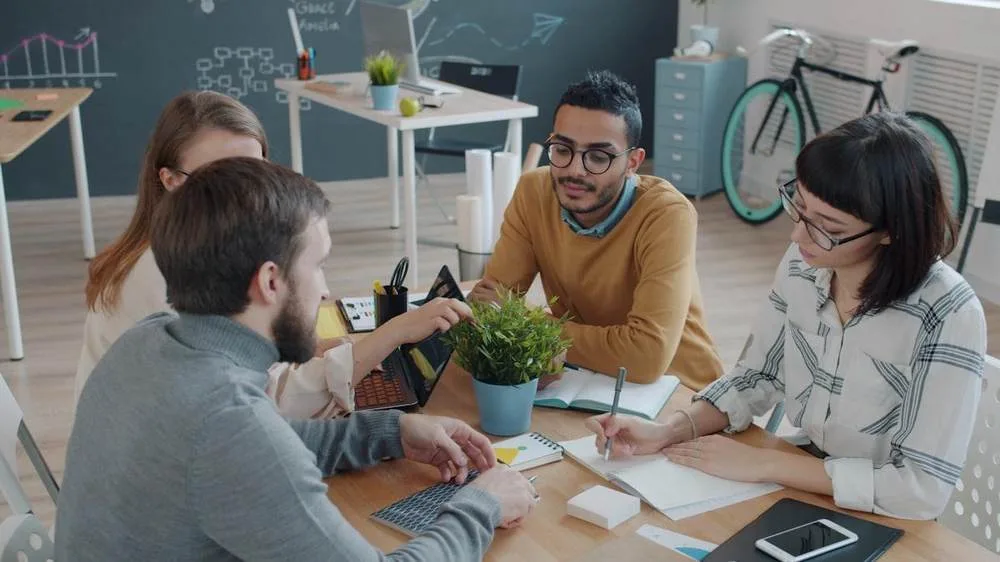 Team werkt samen rond een tafel met laptop